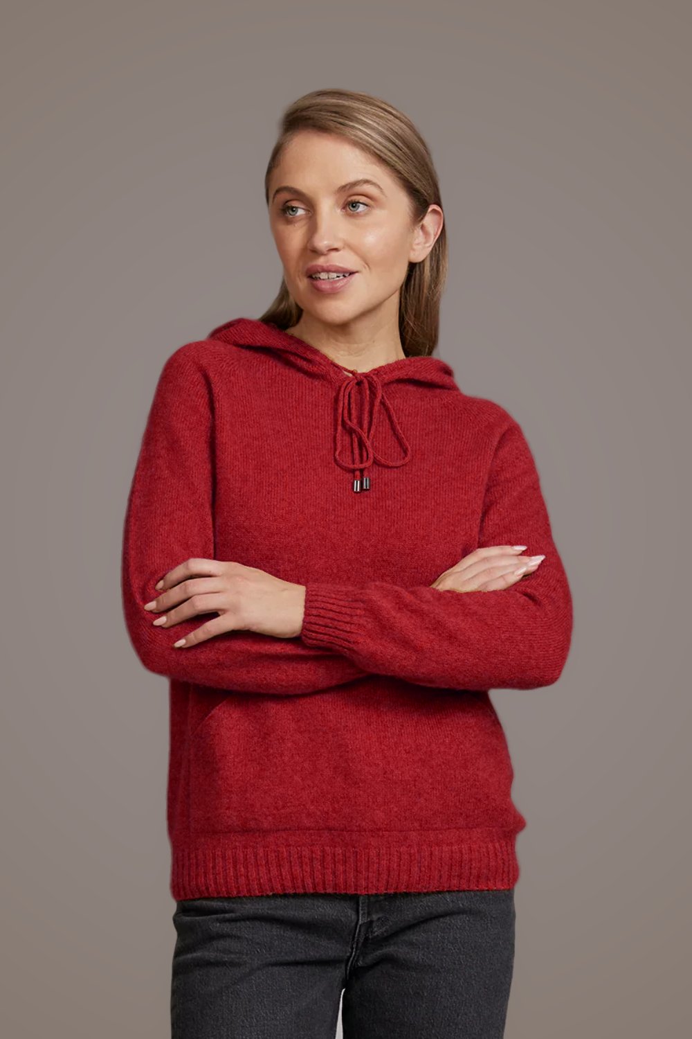 Woman wearing the Casual Possum Merino Hoodie in Red by McDonald against a plain background