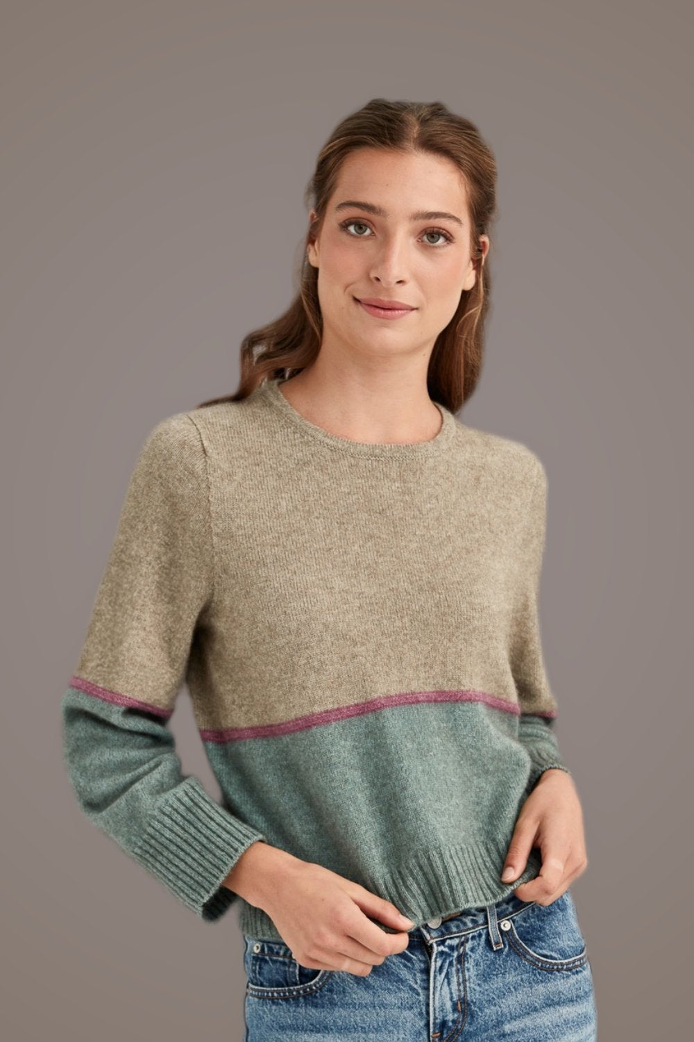 Woman wearing the Horizon Possum Merino Jumper in Hydrangea by McDonald on a gray background