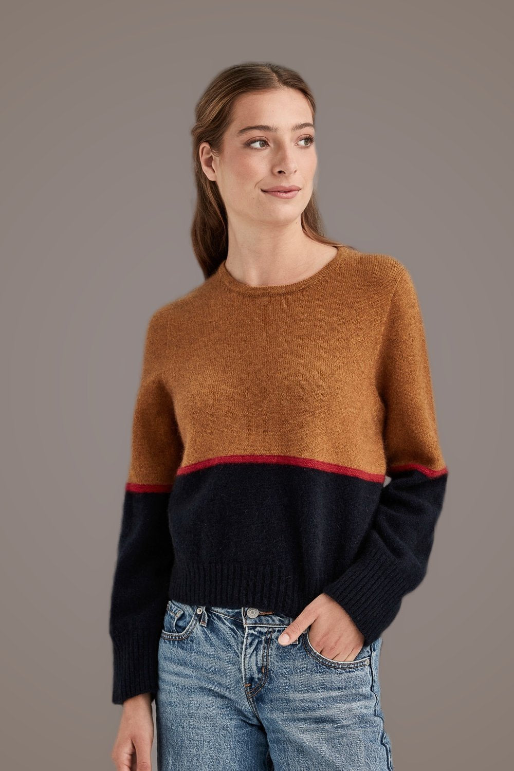 Woman wearing the Horizon Possum Merino Jumper in Wallace by McDonald on a gray background, hand in pocket