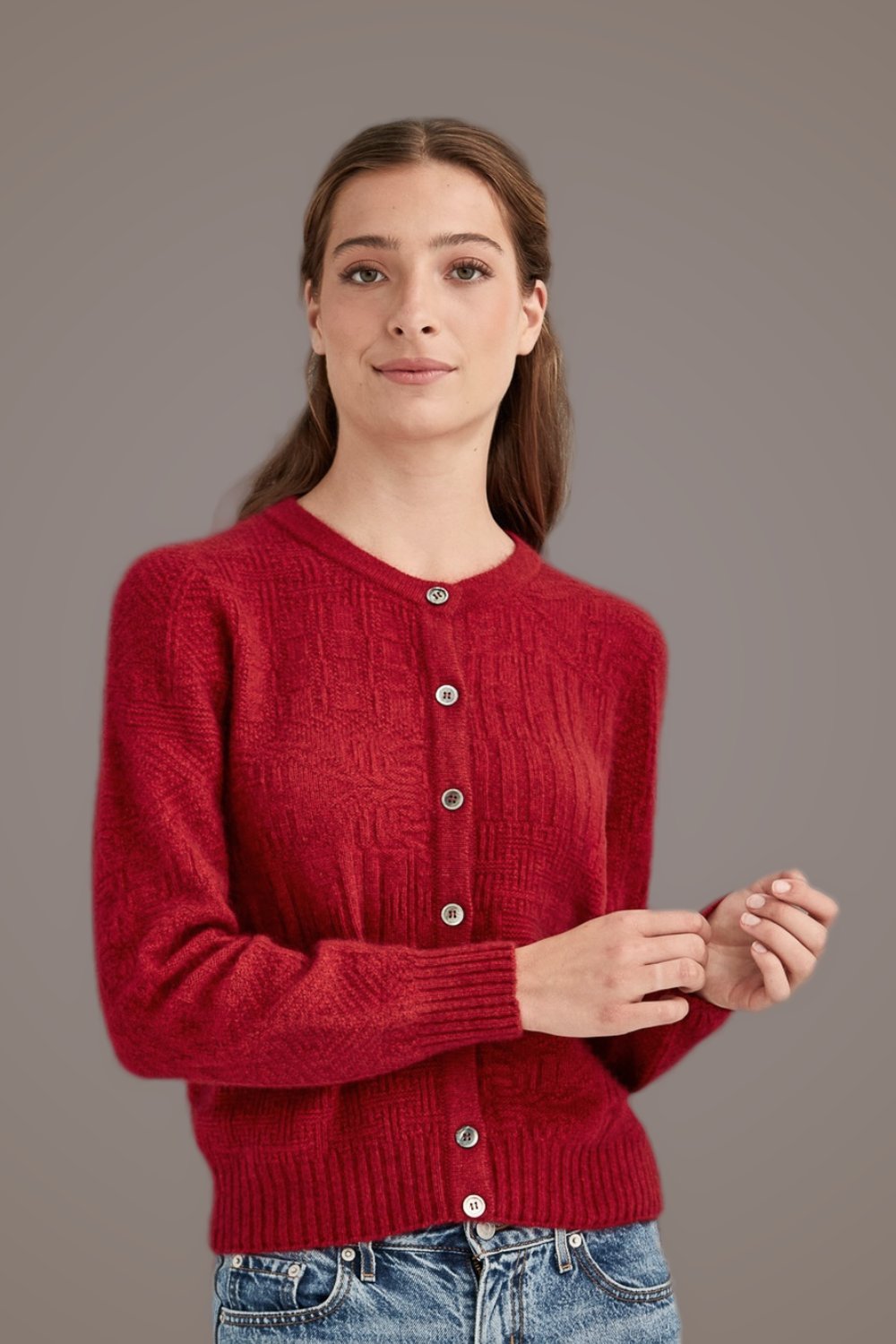 Woman wearing the Patchwork Possum Merino Cardigan in Red by McDonald against a plain background