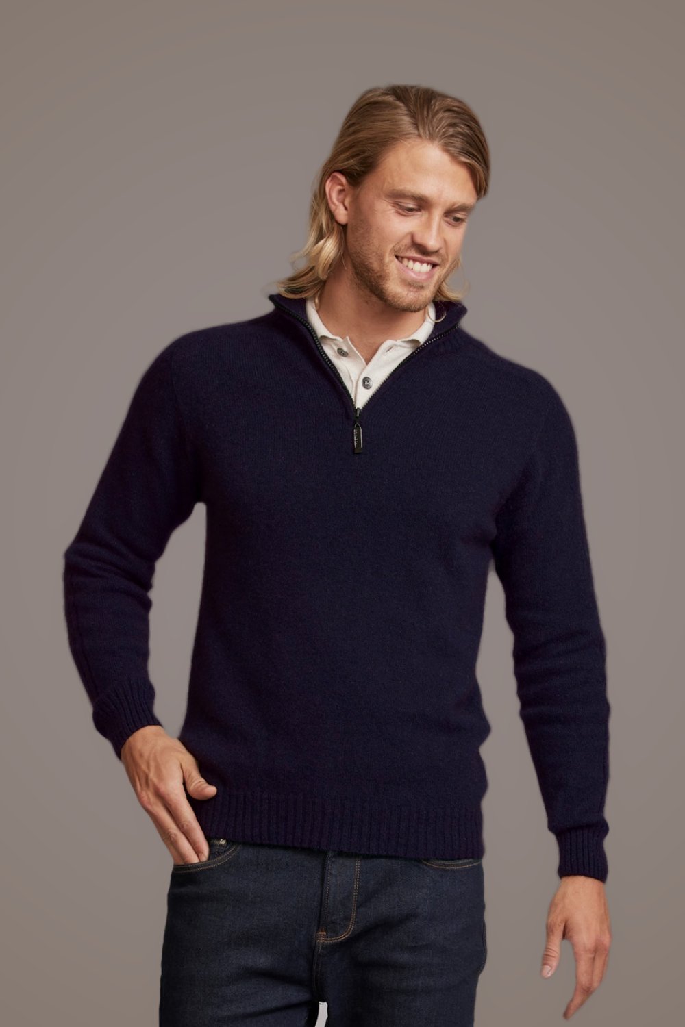 Man wearing the Short Zip Rib Sleeve Possum Merino Sweater in Navy by McDonald over a white shirt on a gray background