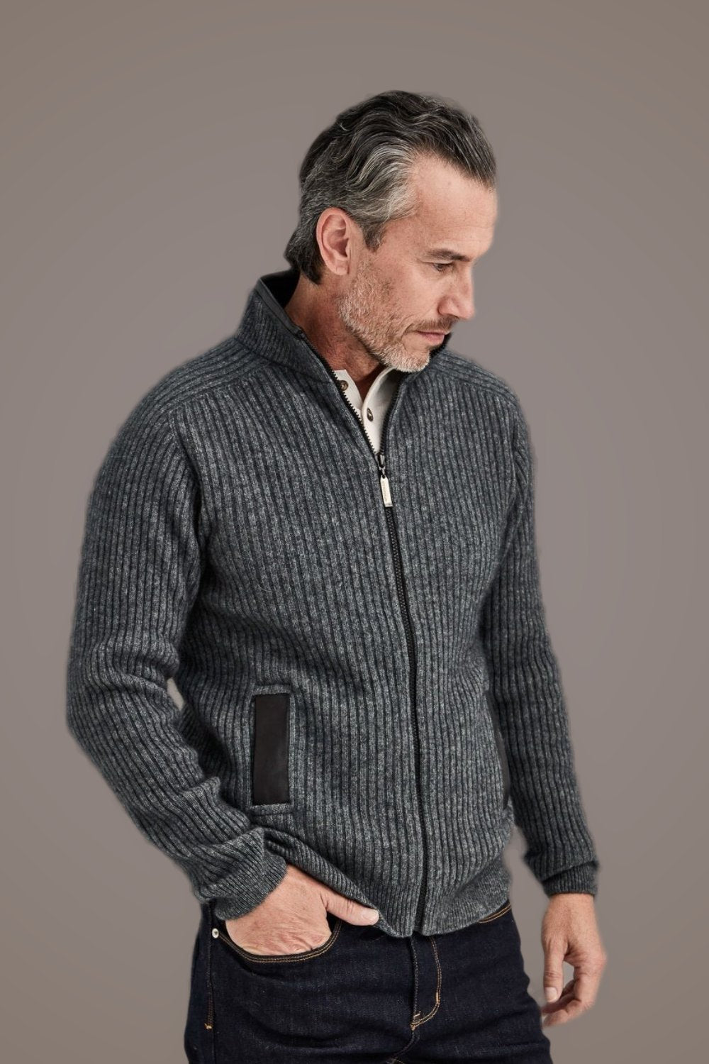 Man wearing the Rib Zip Possum Merino Jacket with Leather Trim in Pewter by McDonald against a plain background