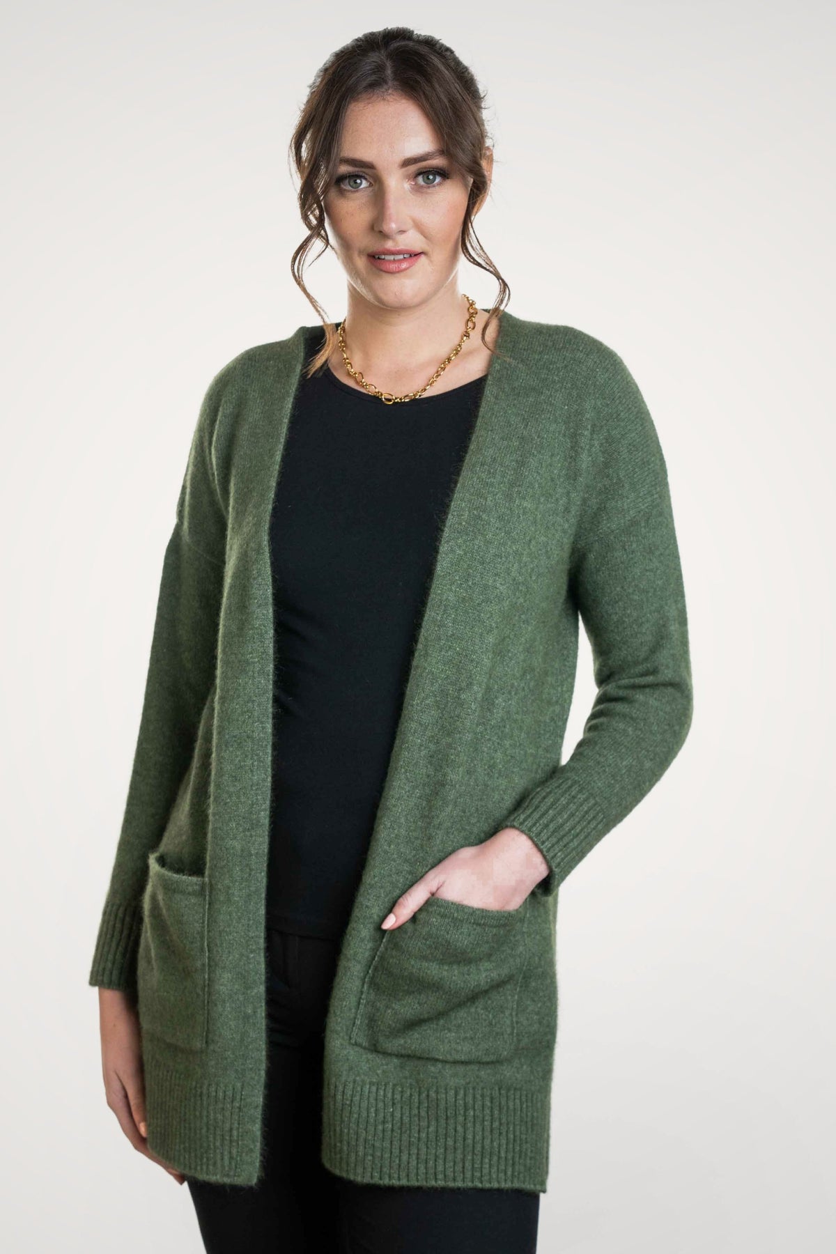 Woman wearing the Longline Possum Merino Cardigan in Moss by Koru on a white background