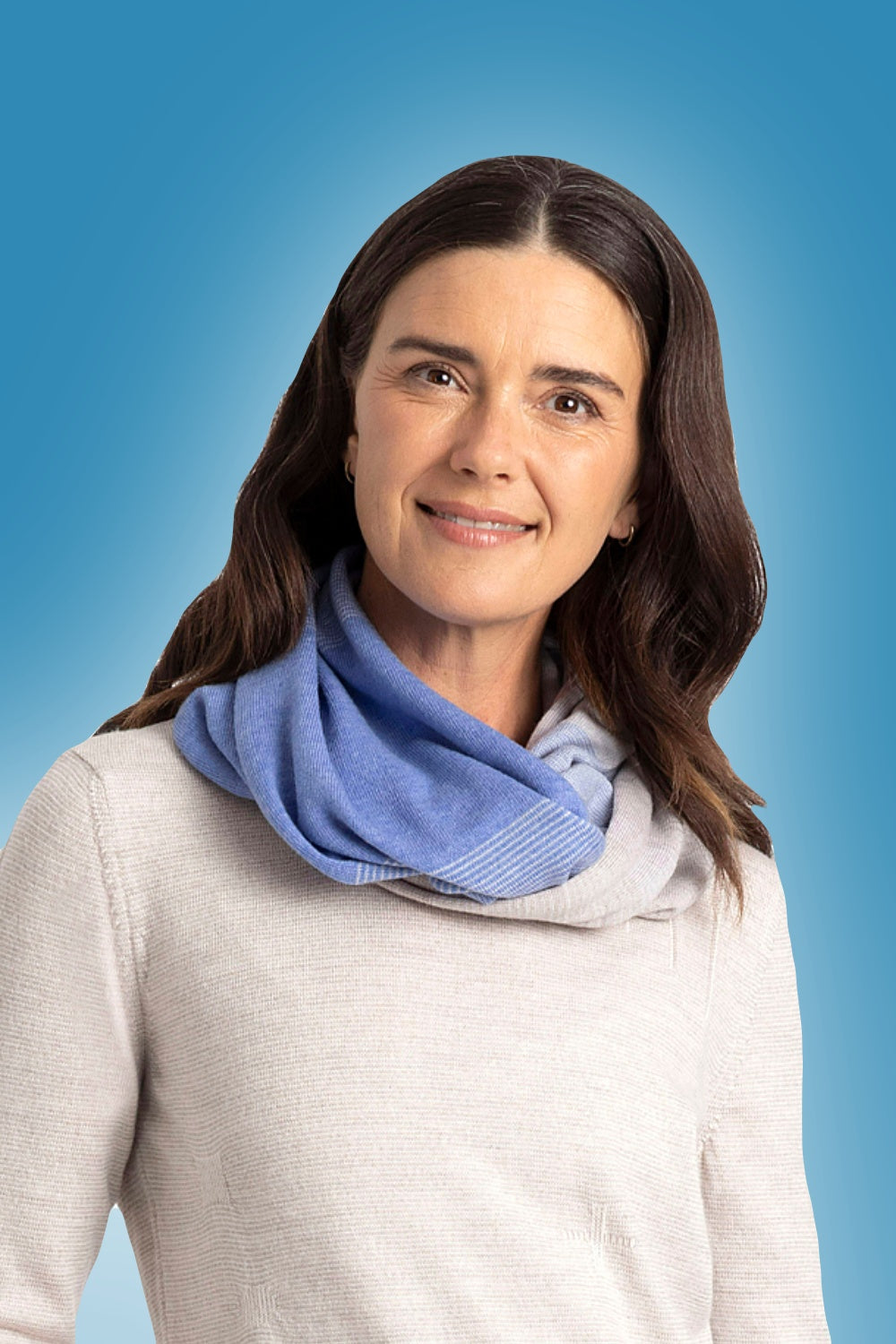 Woman wearing the Graduated Stripe Merino Infinity Scarf in Chambray by Royal Merino against a blue background