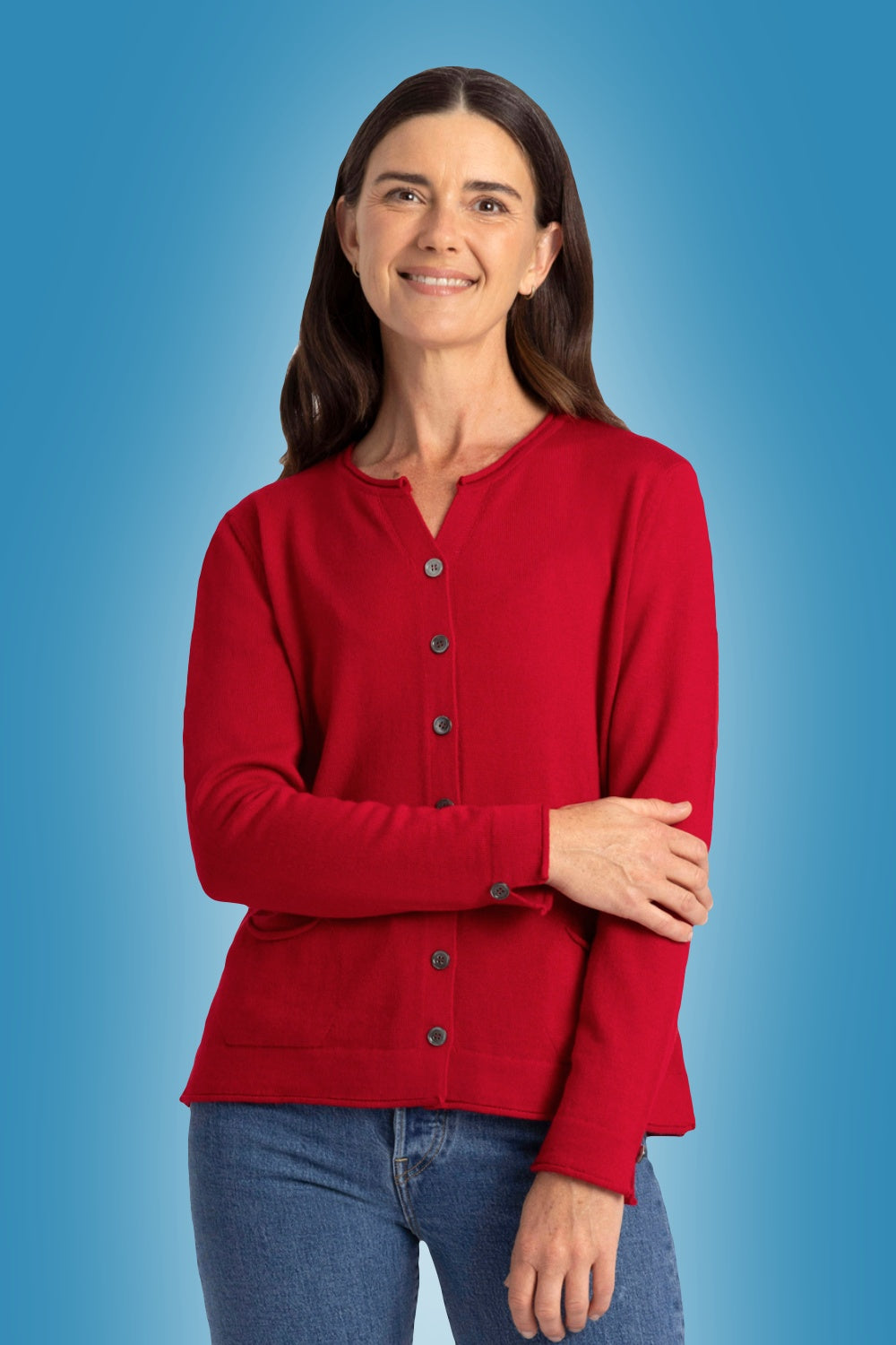 Woman wearing the Pocket Merino Cardigan in Tamarillo by Royal Merino on a blue background