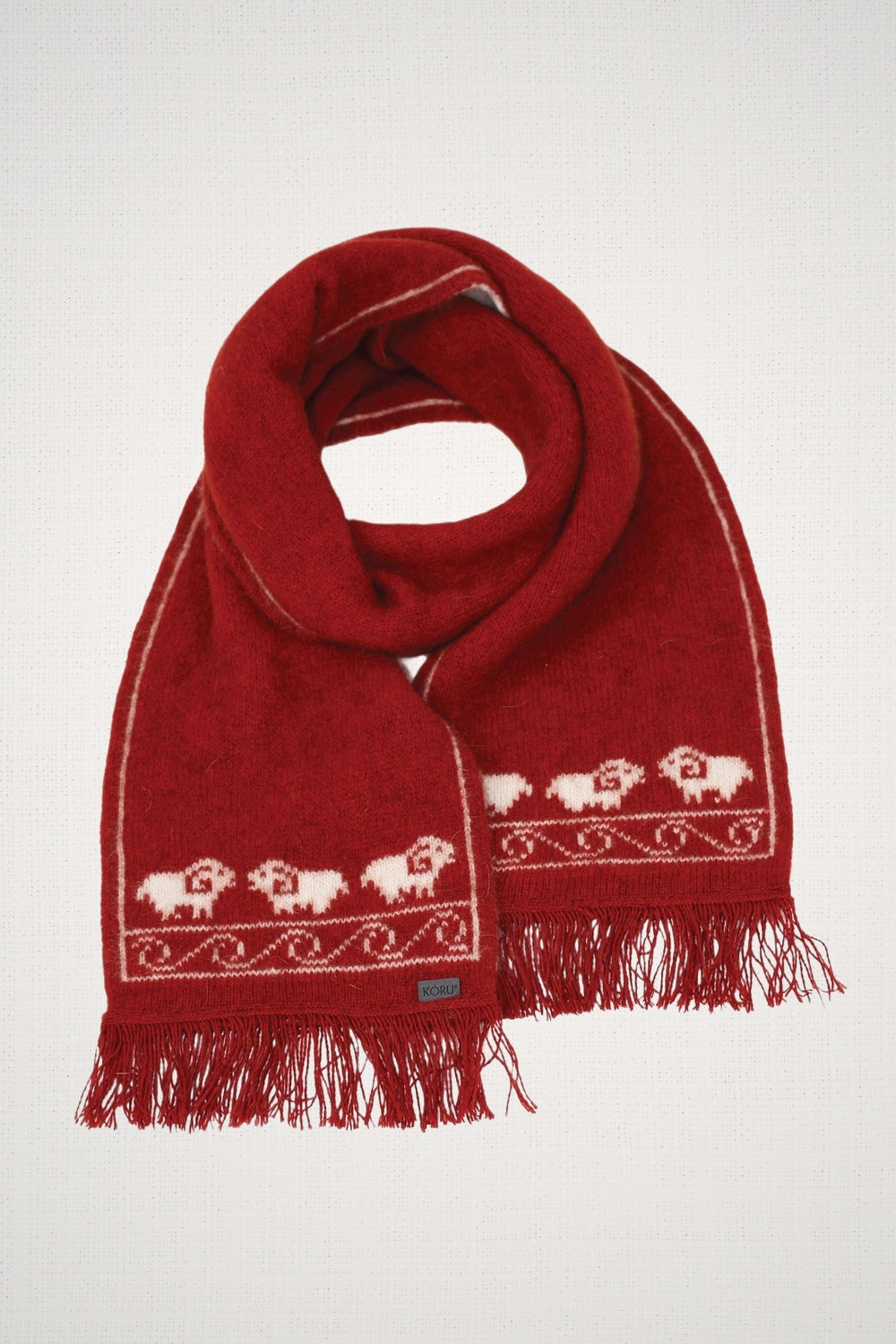Sheep Possum Merino Scarf in Rata by Koru on a light gray background