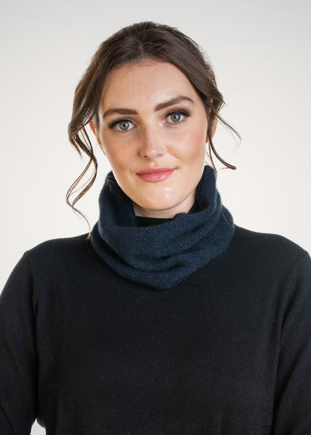 Woman wearing the Possum Merino Neck Warmer in Navy by Koru against a plain background