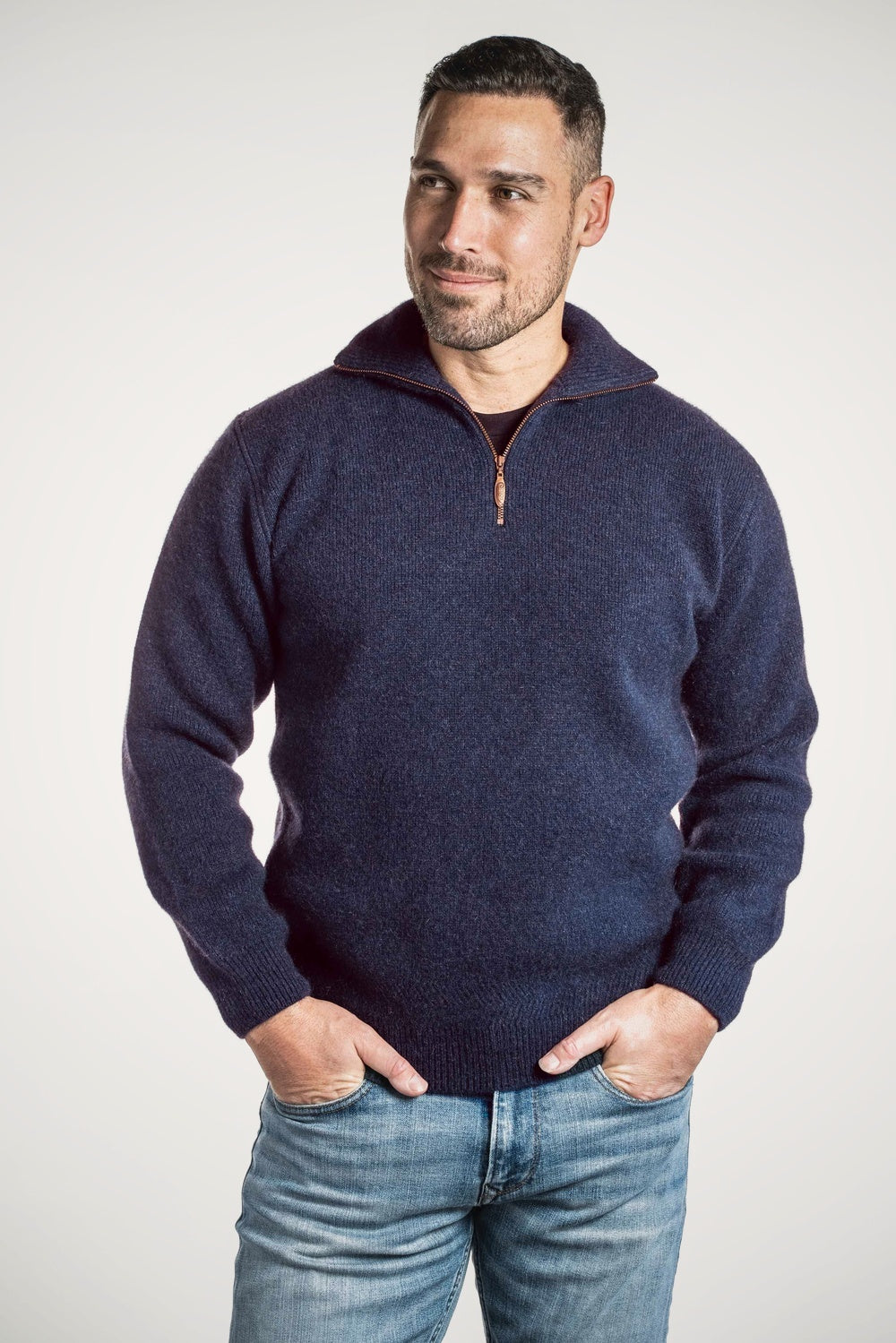 Man wearing the Zip Collar Possum Merino Jumper in Indigo by Koru against a white background