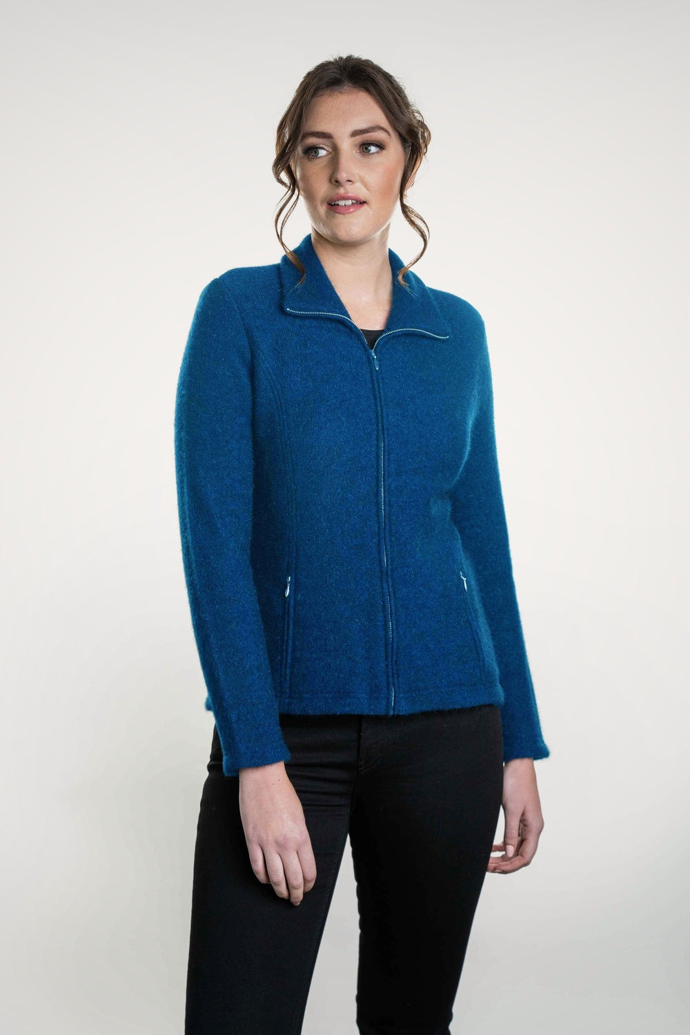 Woman wearing the Shaped Zip Possum Merino Jacket in Pacific by Koru on a white background