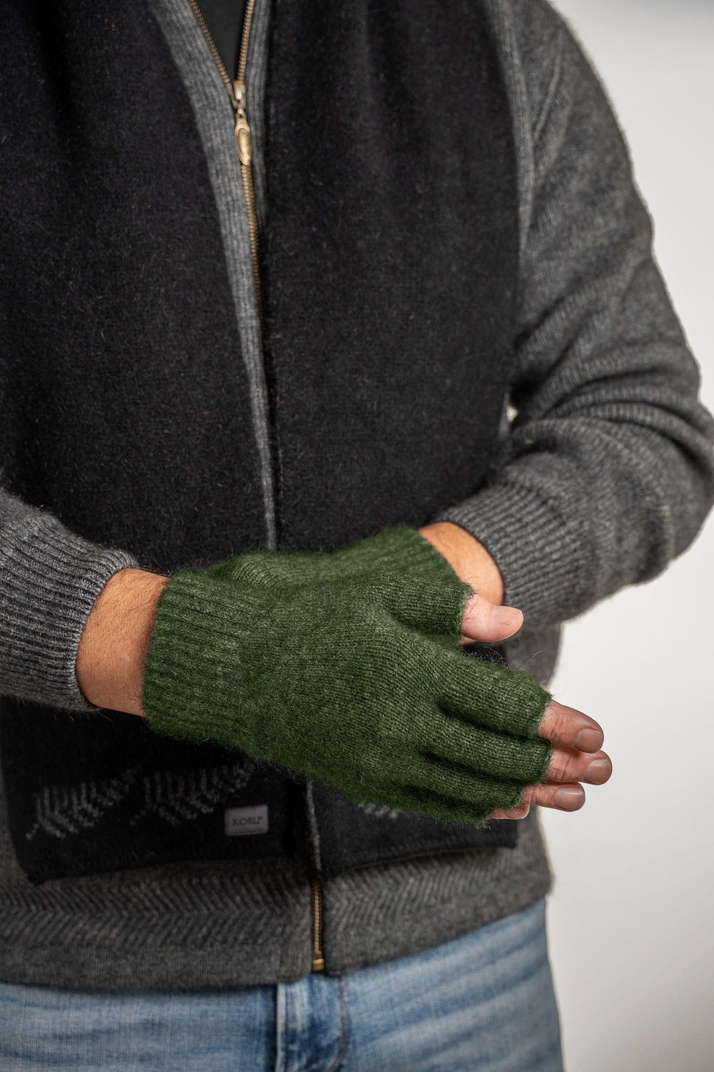 Person wearing the Fingerless Possum Merino Gloves in Moss by Koru