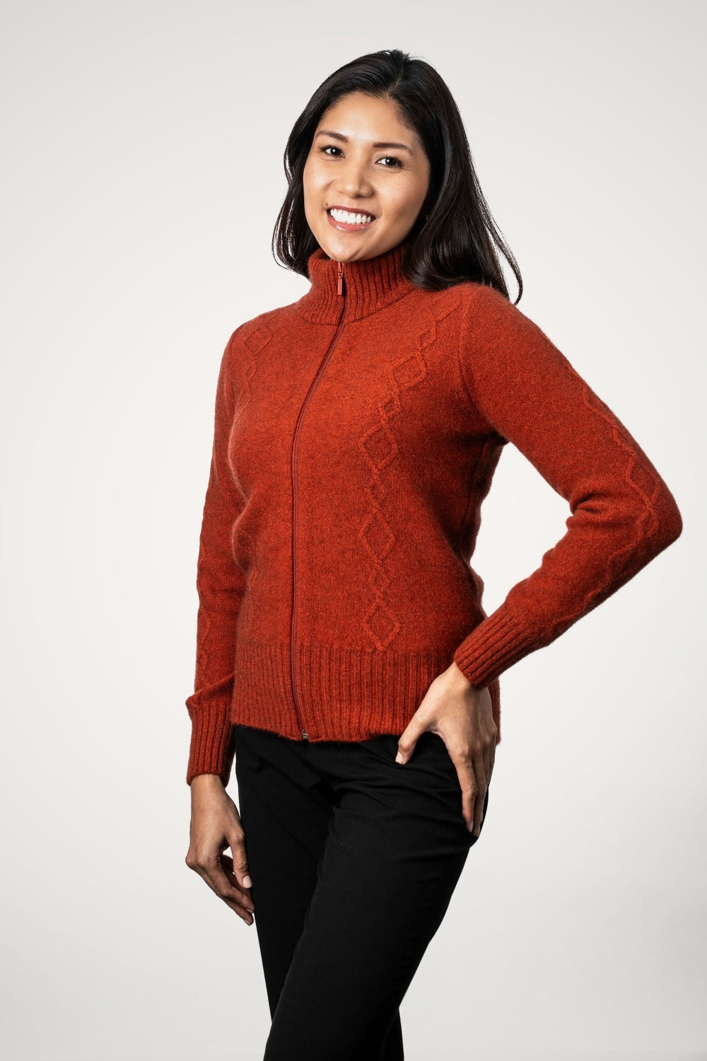 Woman wearing the Cable Detail Possum Merino Jacket in Sienna by Koru against a white background