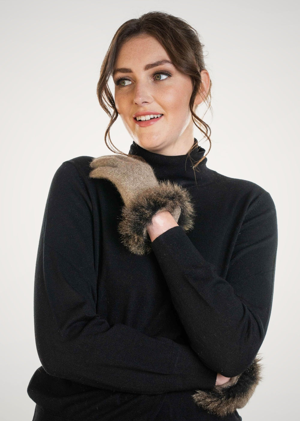 Woman wearing a black turtleneck sweater and the Fur Trim Possum Merino Gloves in Mocha/Snowtip by Koru against a white background
