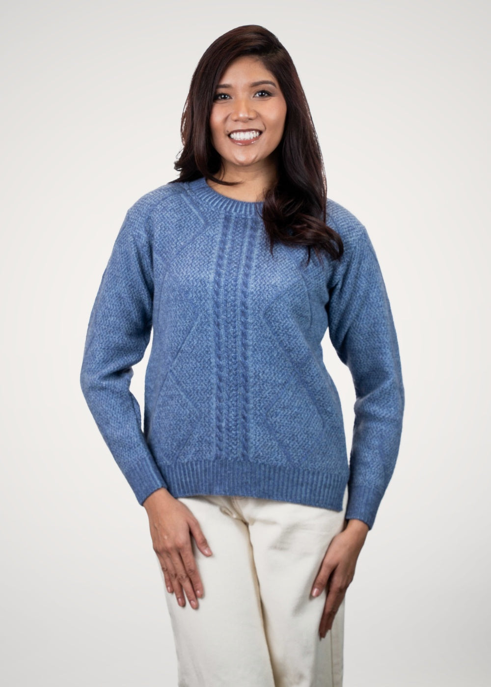 Woman wearing the Diamond Cable Possum Merino Jumper in Periwinkle/Sky by Koru on a white background