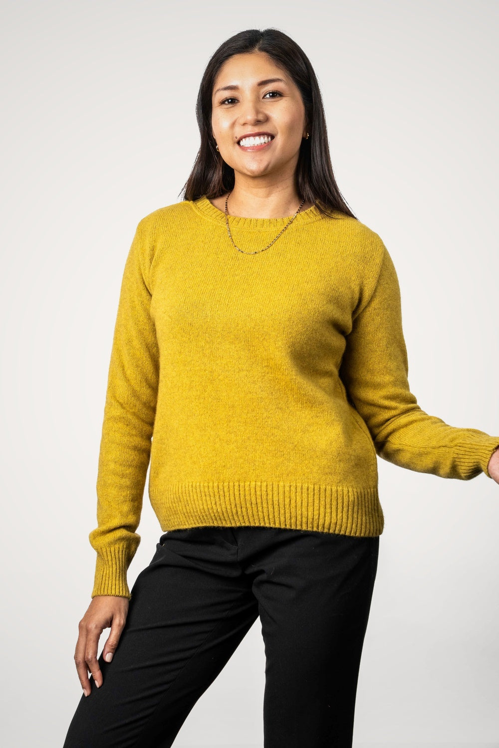 Woman wearing the Crew Neck Possum Merino Jumper in Kowhai by Koru against a white background