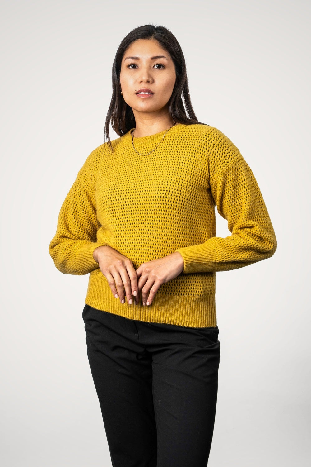 Woman wearing the Crochet Knit Possum Merino Jumper in Kowhai by Koru against a white background